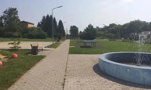 Рабочие укладывают плитку в обновленном сквере деревни Волжанец, готовя площадку для будущих мероприятий.