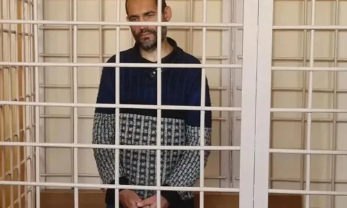 Мужчина в судебном зале, ожидающий решения суда по делу о нападении на полицейского.