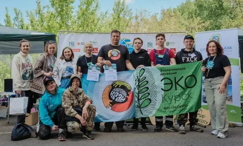 Группа волонтёров на берегу реки в Курской области, убирающих мусор и заботящихся о природе.